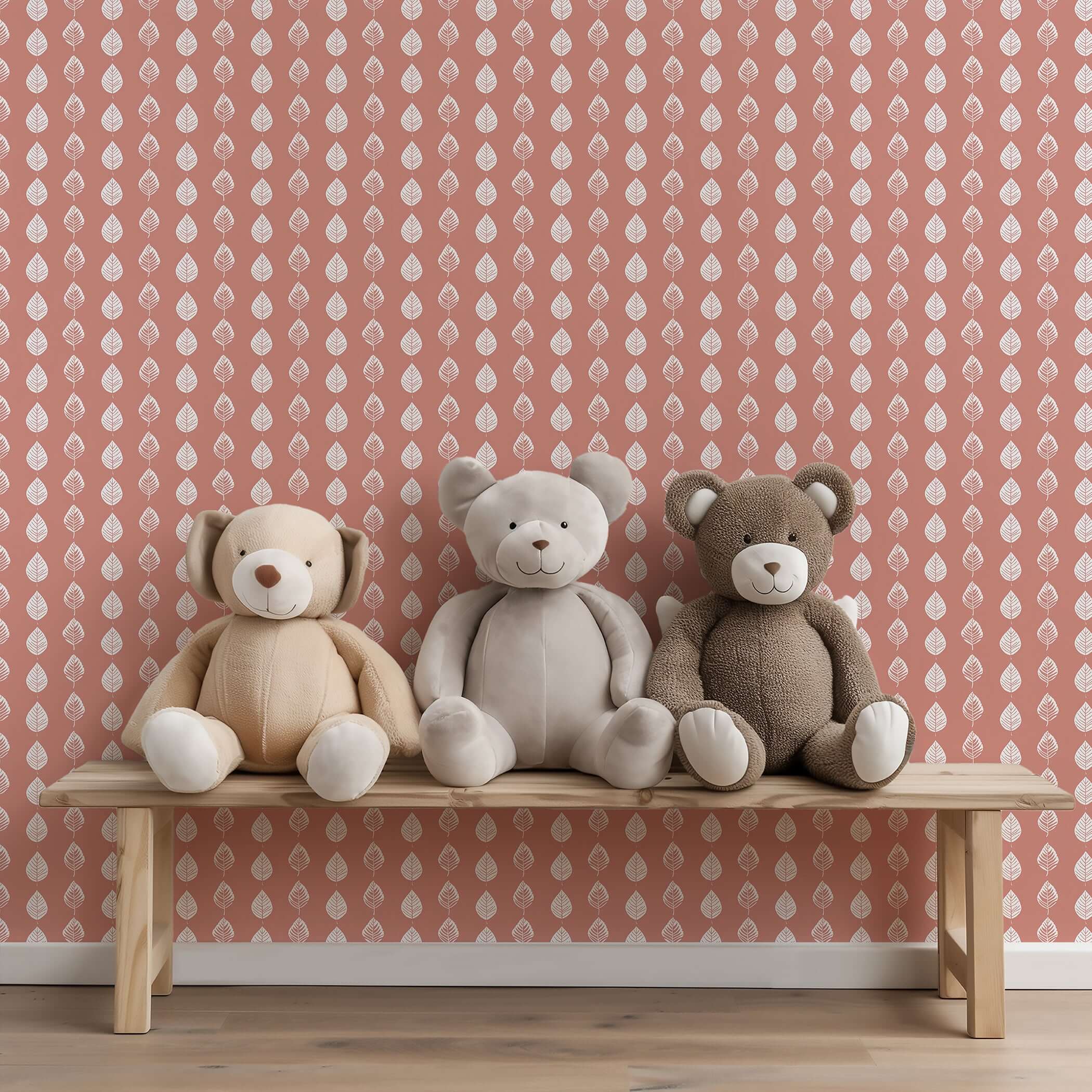 Petal Pink wallpaper with leaf pattern behind three plush bears on a bench, perfect for modern nurseries or playrooms.