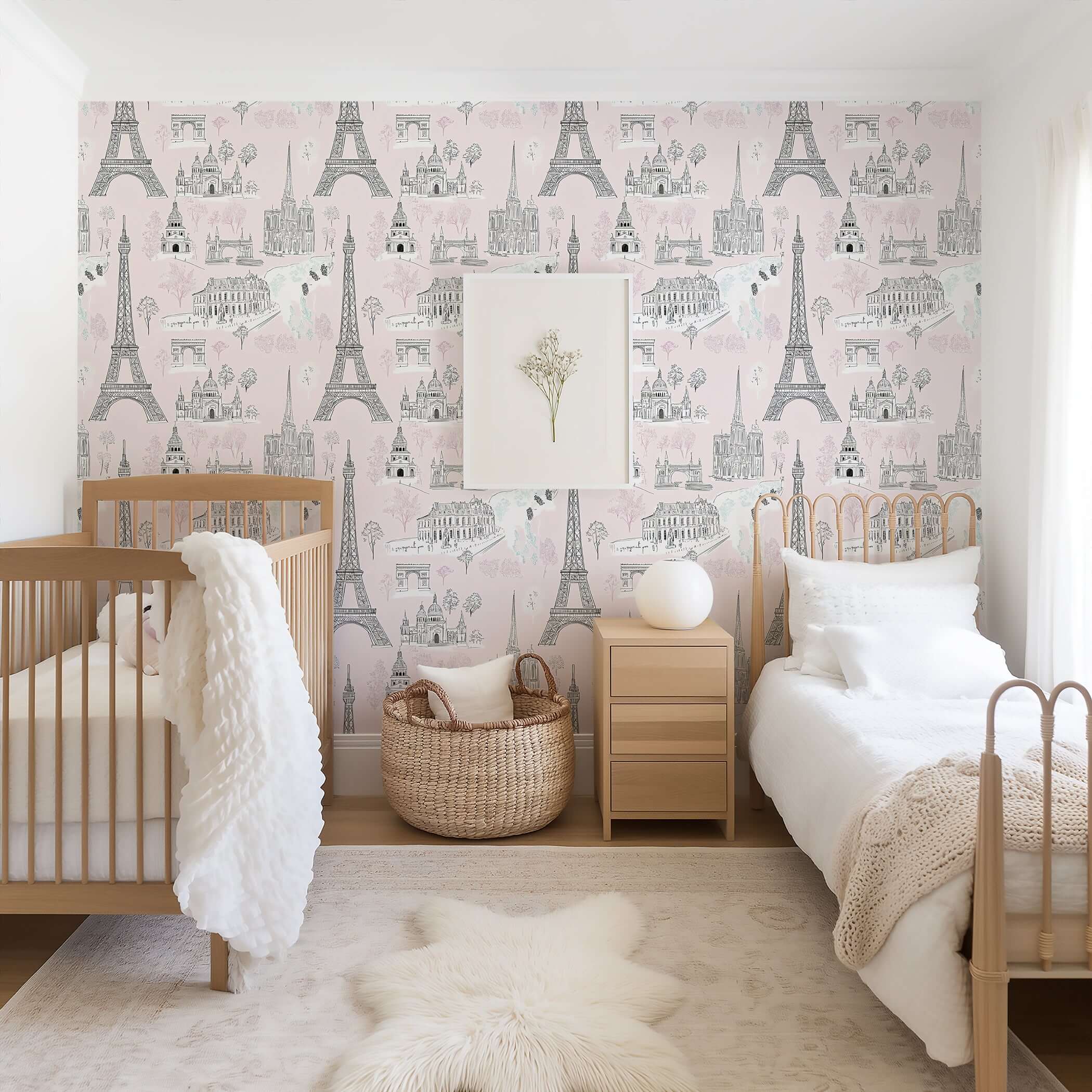 Stylish nursery with soft pink Paris wallpaper featuring Eiffel Tower, Arc de Triomphe, Notre Dame. Perfect for kids' playroom.