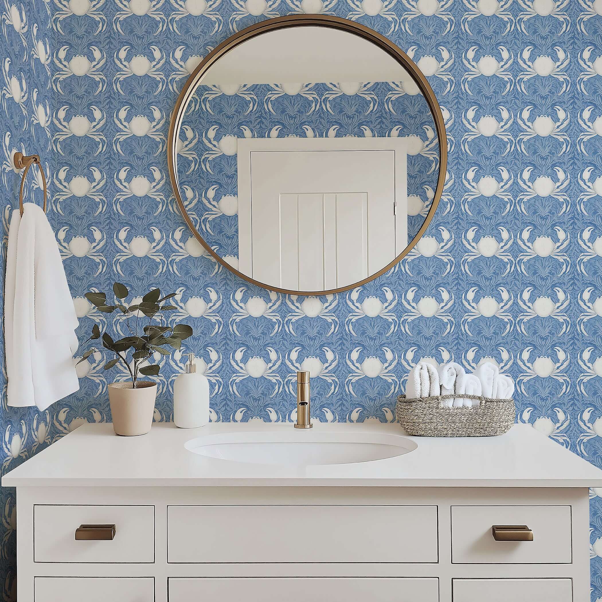 Elegant blue coastal wallpaper featuring white crabs and sea foliage in a bathroom with a round mirror and modern vanity.
