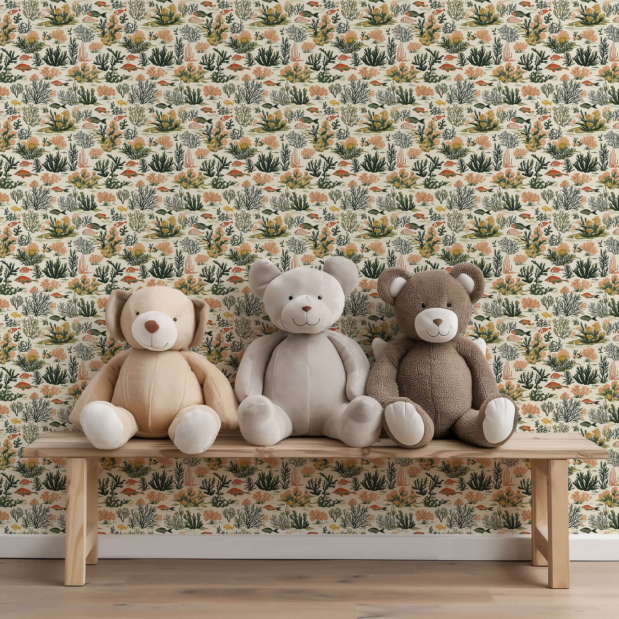 Tropical Tide coastal wallpaper with coral, fish, seaweed design behind three stuffed bears on a wooden bench.