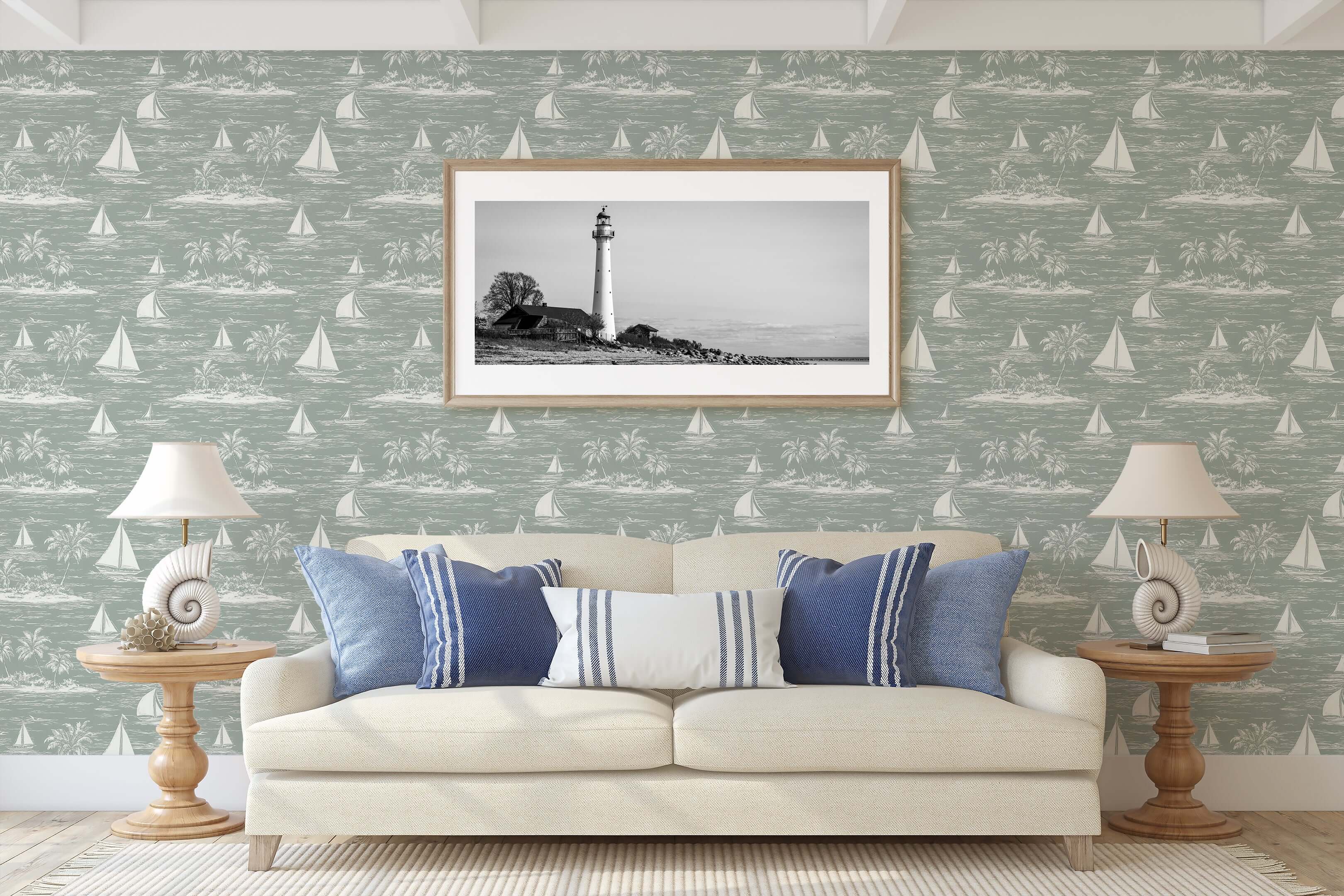 Living room with Harbor Calm coastal wallpaper featuring boats, ocean, palm trees, and a lighthouse print above a white sofa.
