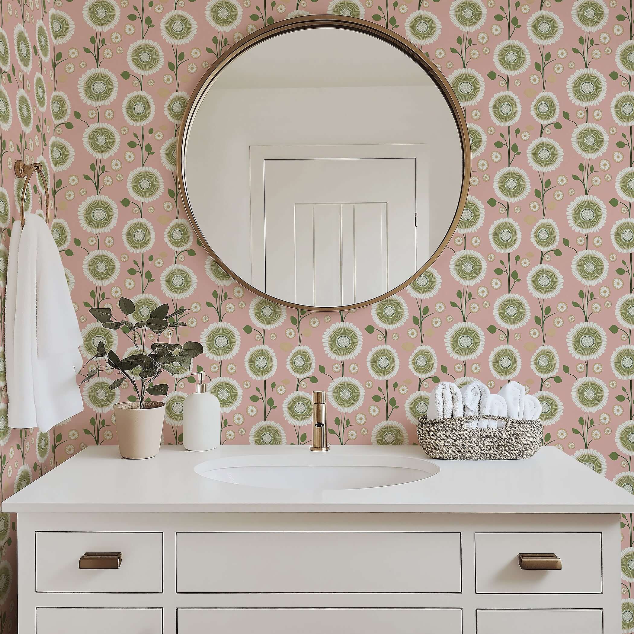 Round mirror above a white vanity with Pastel Petal Perfection wallpaper featuring green and white floral patterns on a pink background.