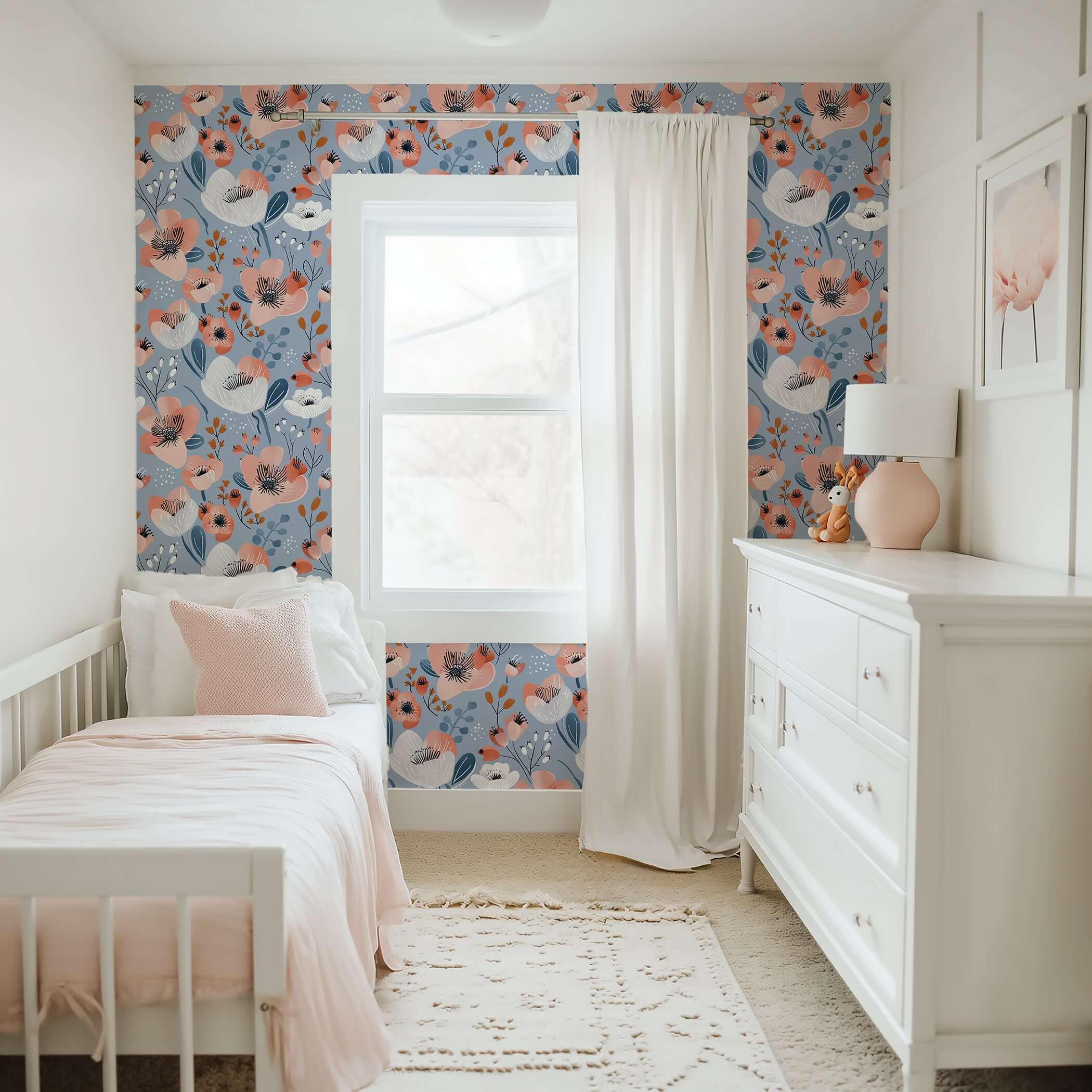 Modern nursery with Blue Breeze Blossom wallpaper featuring whimsical coral, ivory, navy floral patterns on a soothing blue background.