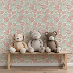 Playful Dahlia Dance wallpaper with soft coral and mint floral patterns, featuring three plush teddy bears on a bench.