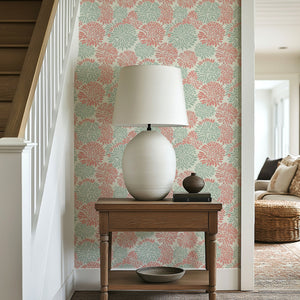 Dahlia Dance wallpaper in soft coral and mint green, enhancing a modern living space with floral patterns.