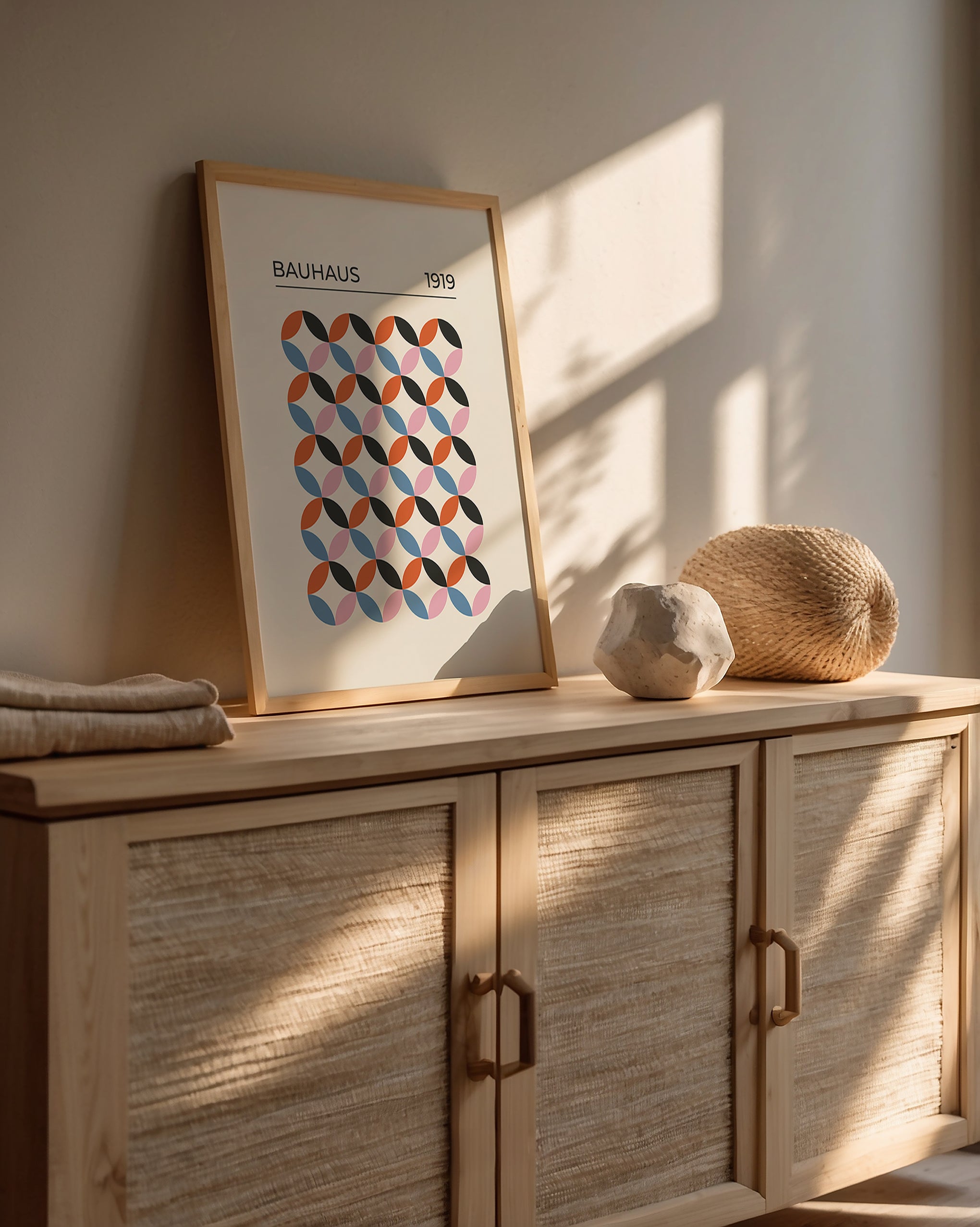 Bauhaus-inspired wall art print with geometric pattern in retro colors on a wooden console.