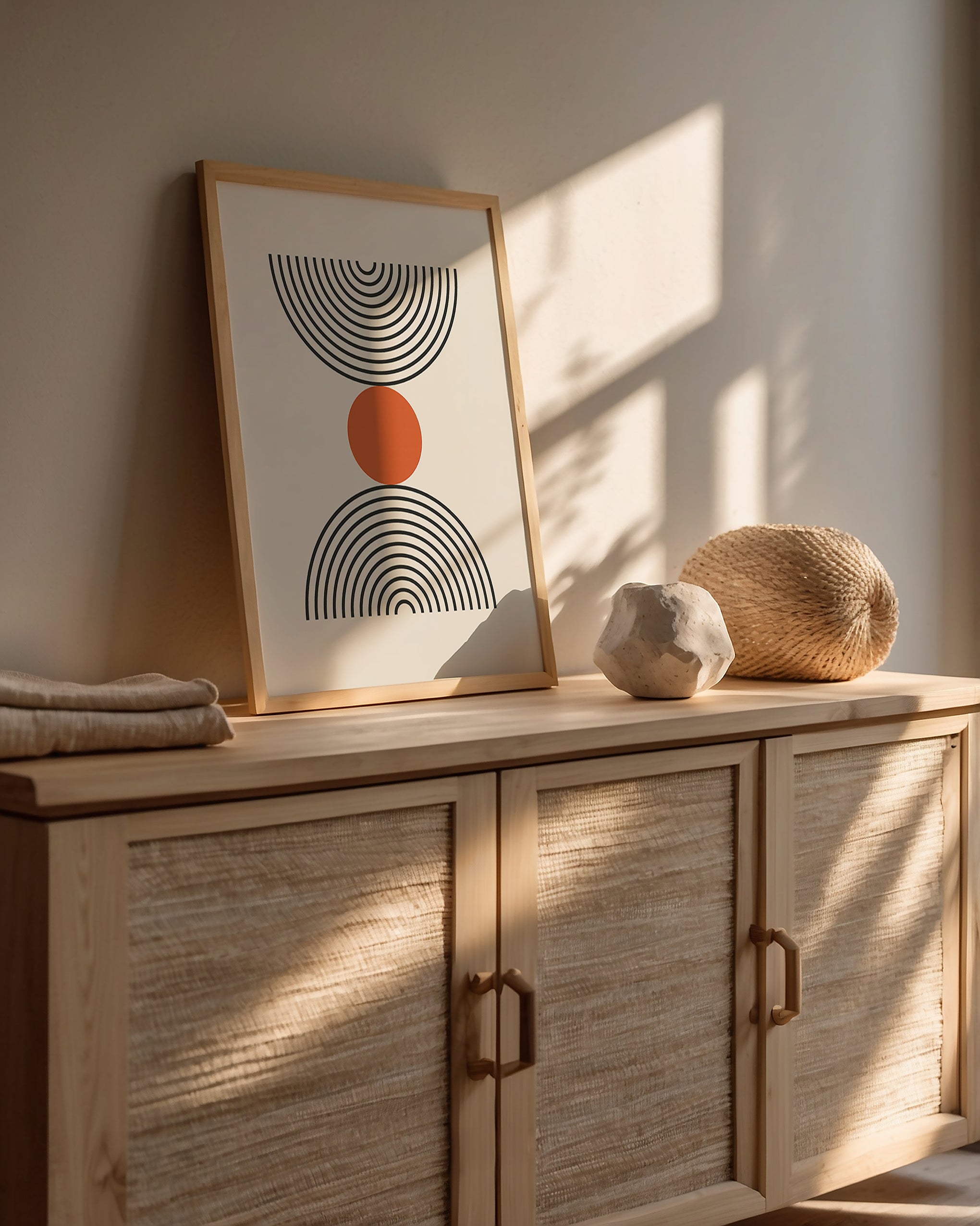 Bauhaus-inspired wall art print showcasing concentric semicircles and a burnt-orange circle on a wooden console.