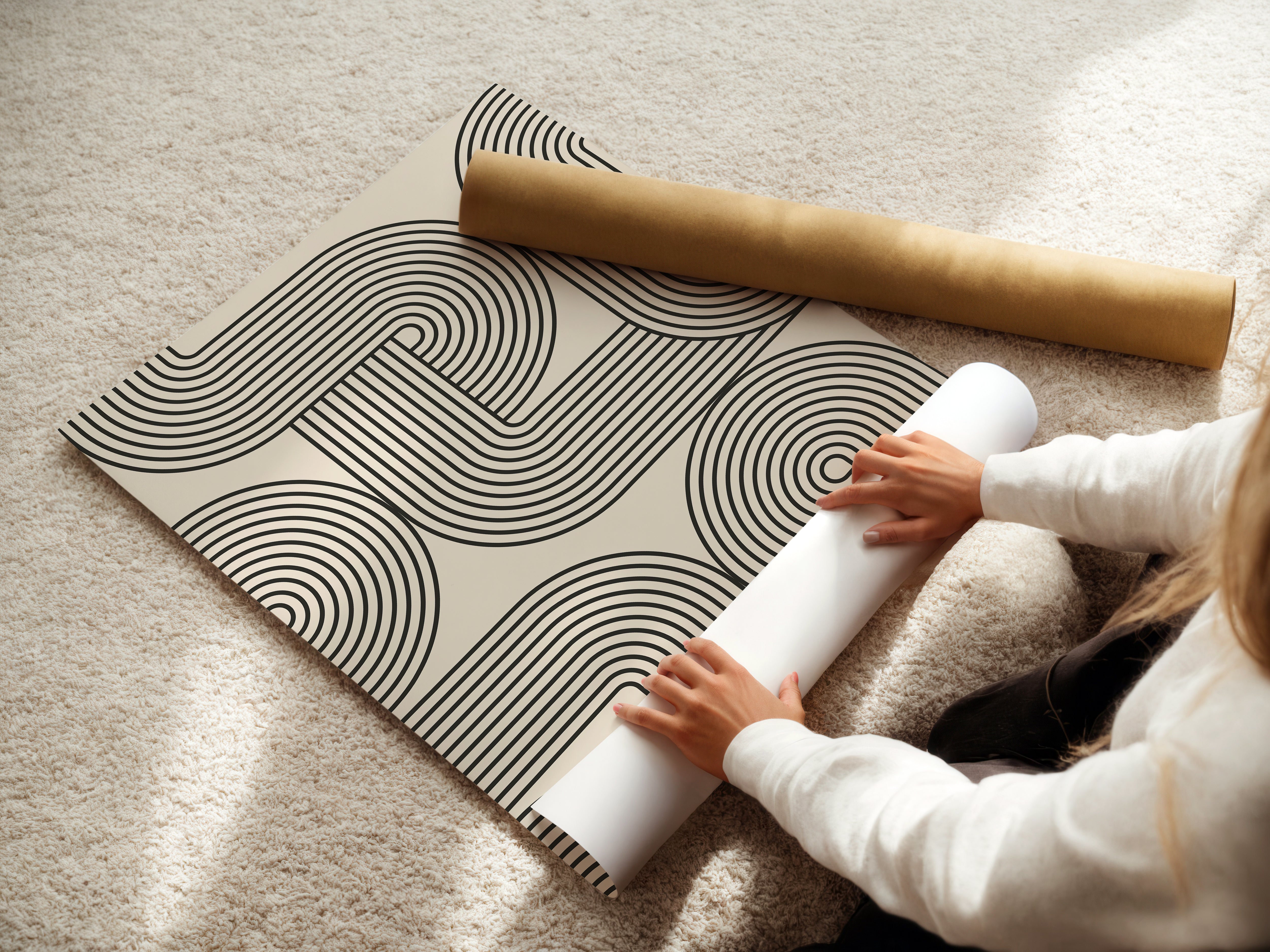 Person unrolling Monoline Motion art print featuring minimalist Bauhaus design with black lines on cream.