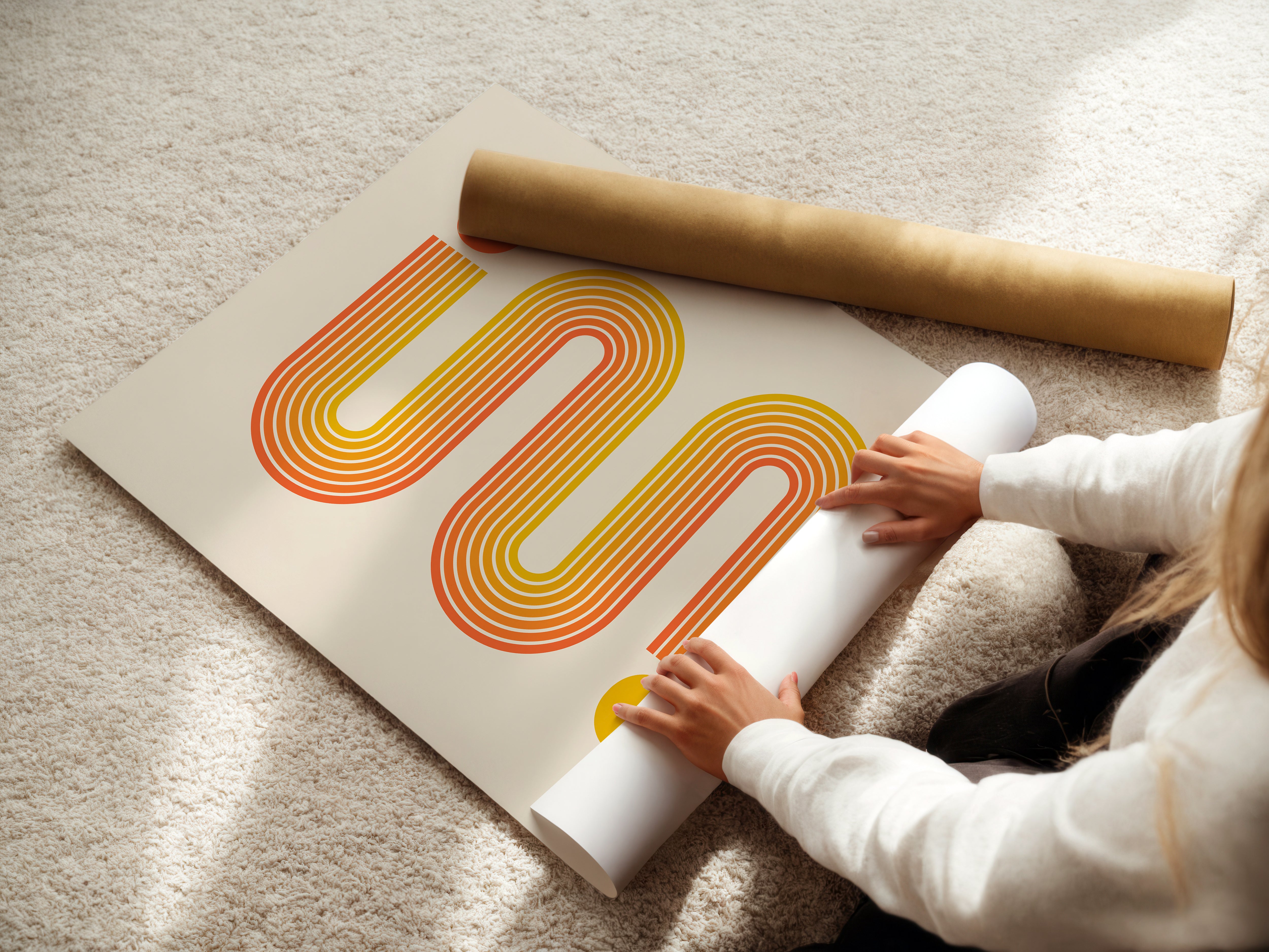Person unrolling a Bauhaus art print featuring vibrant sunset-toned lines and circles on a textured surface.