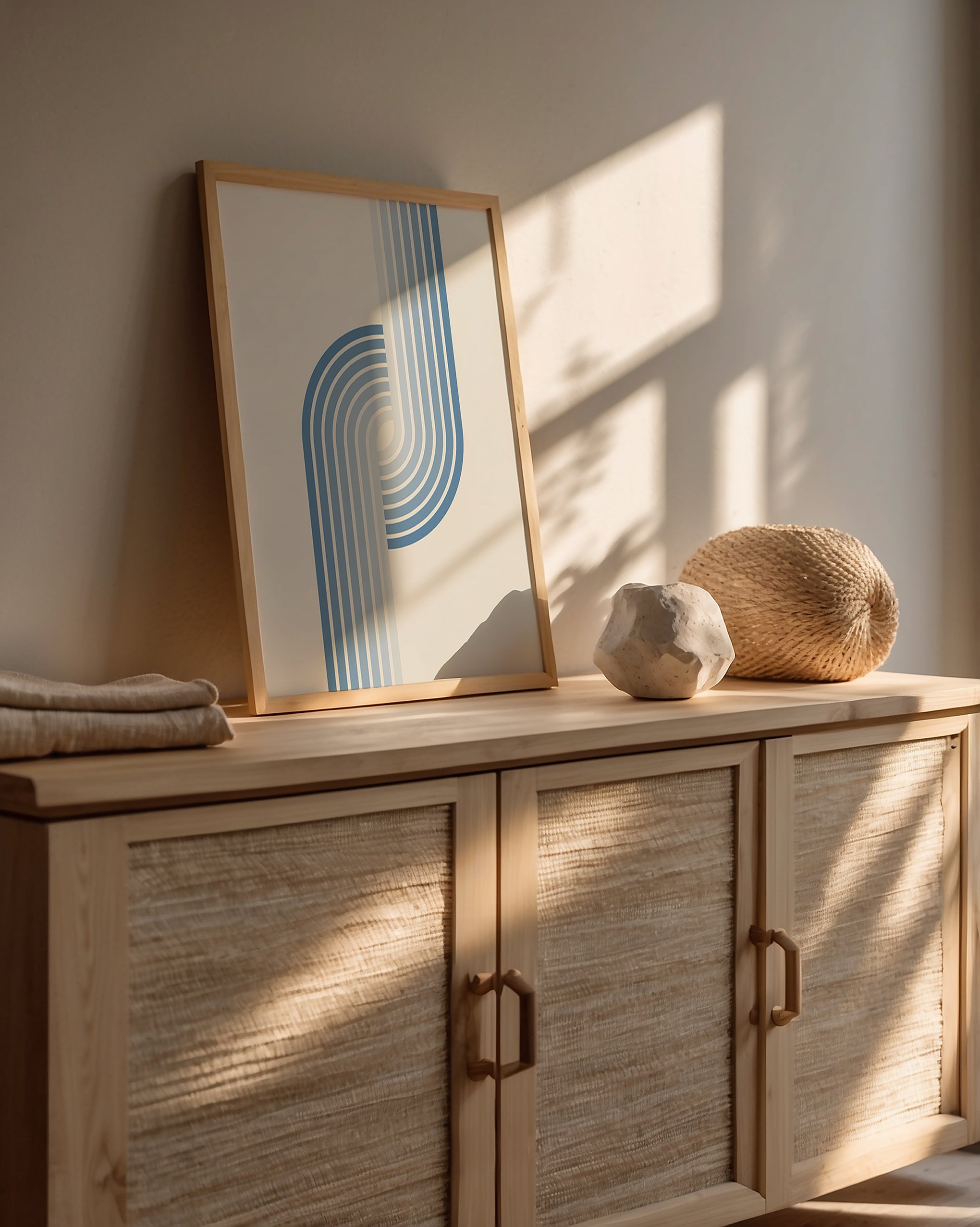 Minimalist Bauhaus wall art print with blue stripes on a wooden console table, showcasing modern design elegance.