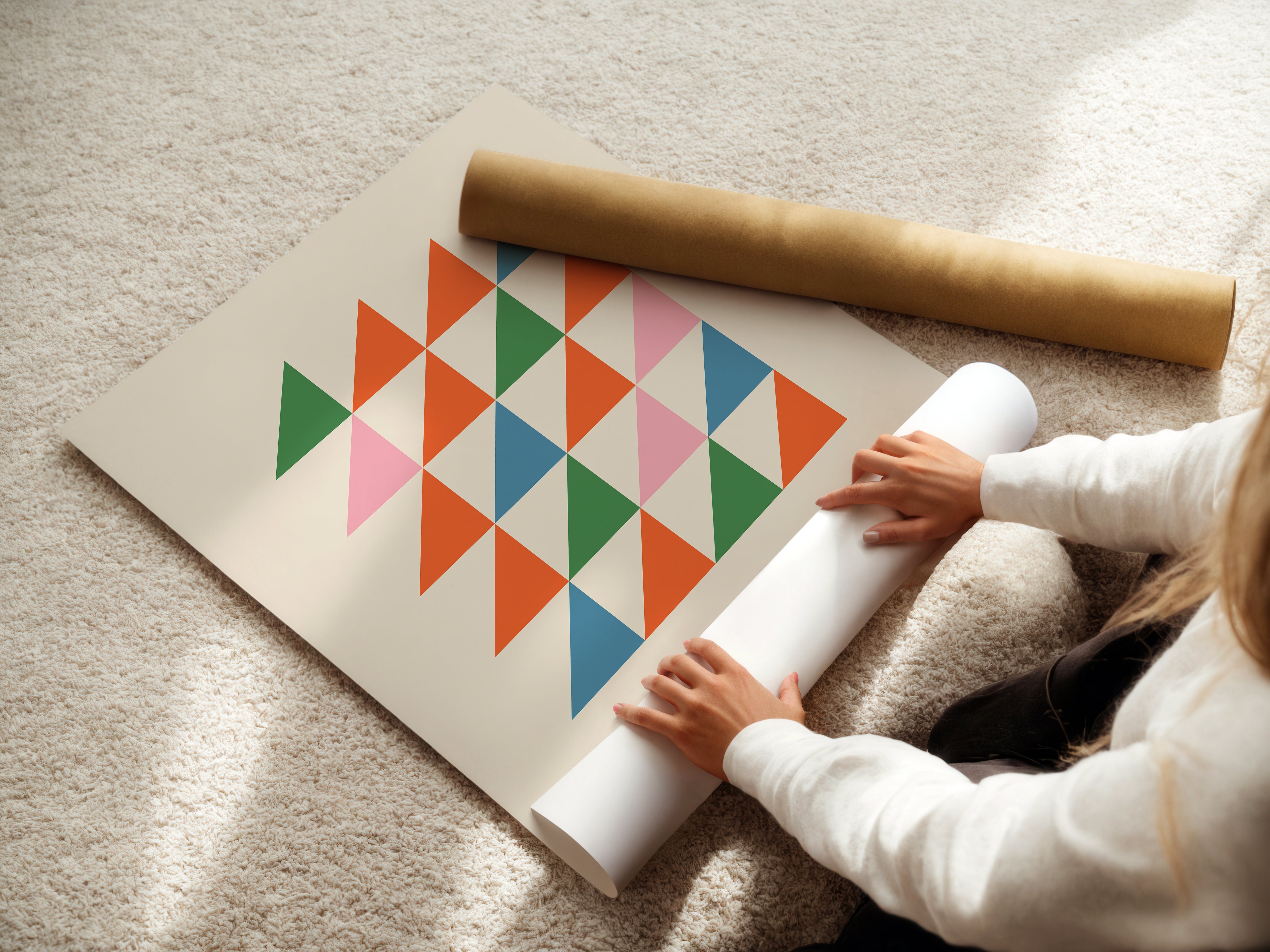 Person handling a colorful Bauhaus art print featuring minimalist triangles in vivid shades.