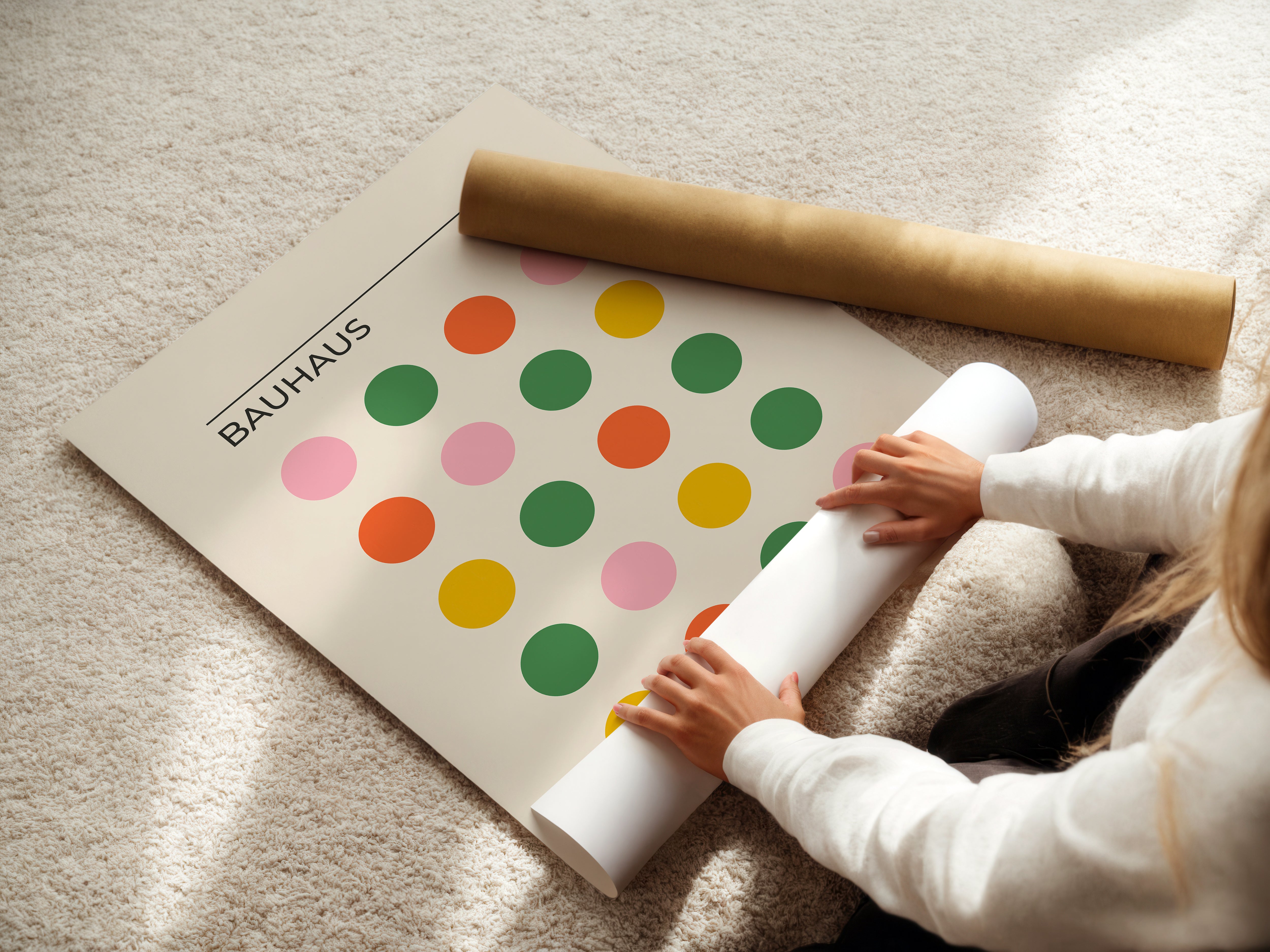 Person preparing a vibrant Bauhaus art print featuring colorful dots for display in a contemporary home.