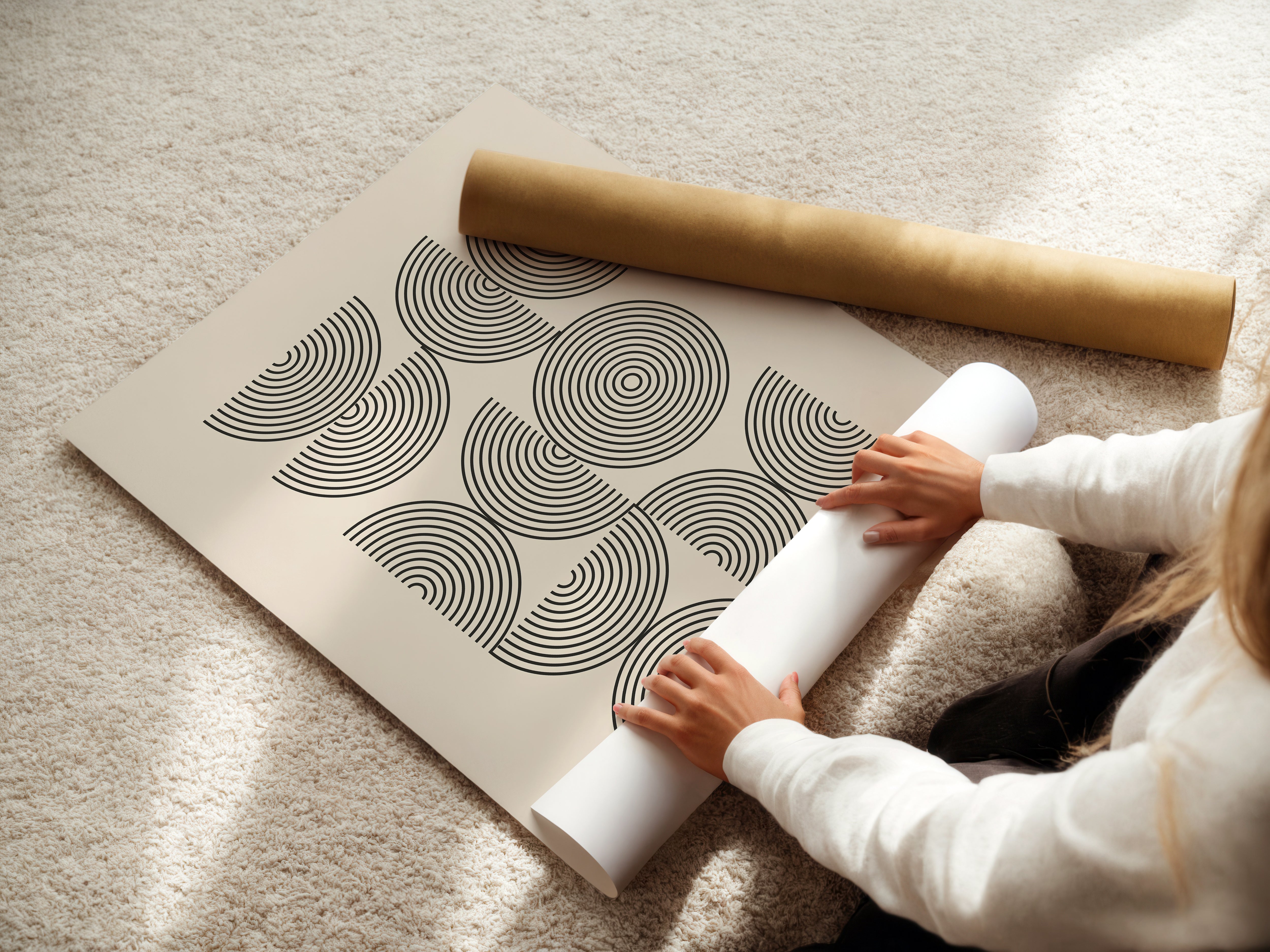 Person unrolling a Bauhaus-inspired art print titled 'Structured Echoes' with geometric patterns and concentric circles.