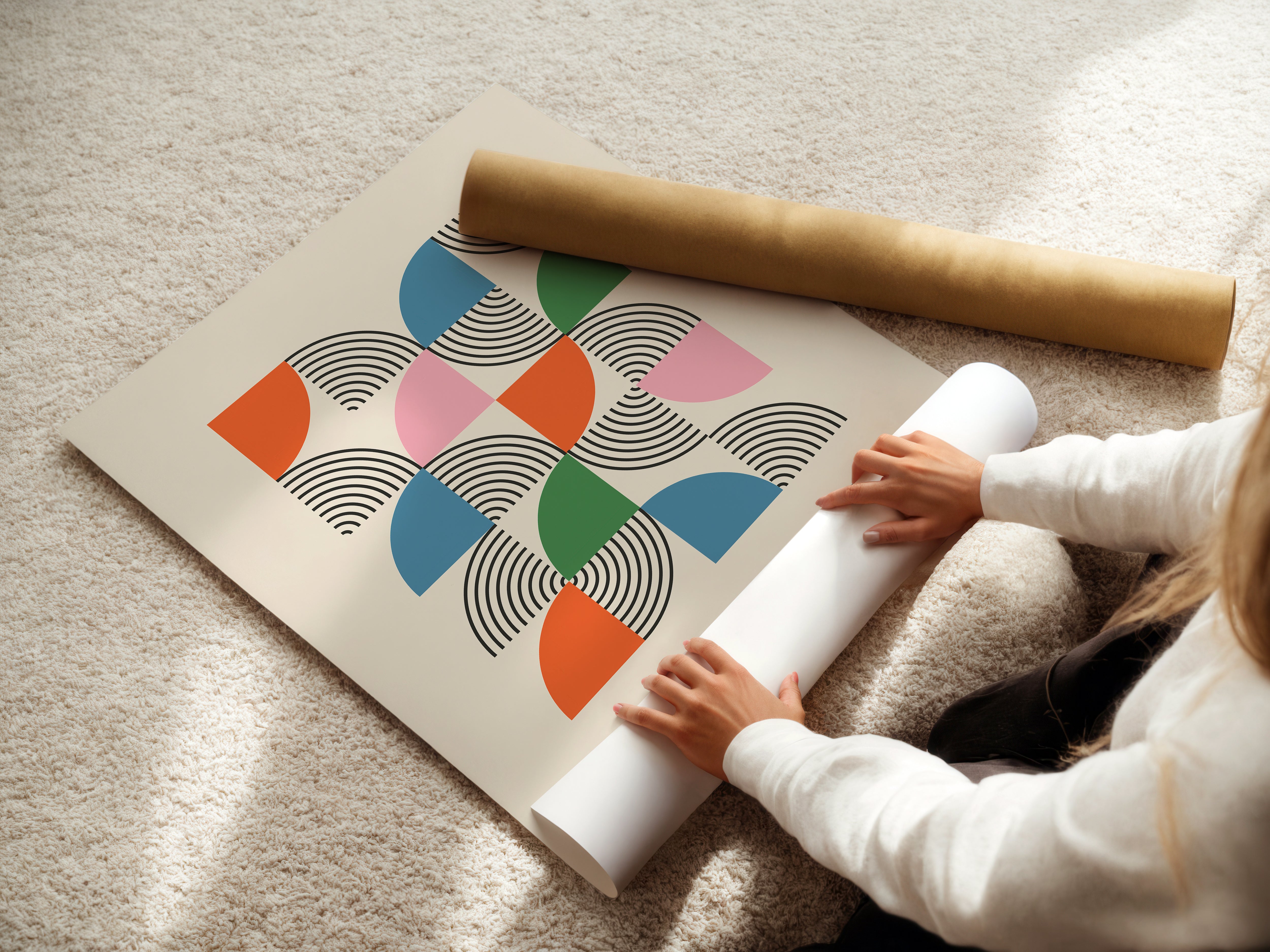 A person unrolling the Modernist Mosaic art print featuring colorful semicircles and black linework, inspired by Bauhaus design.