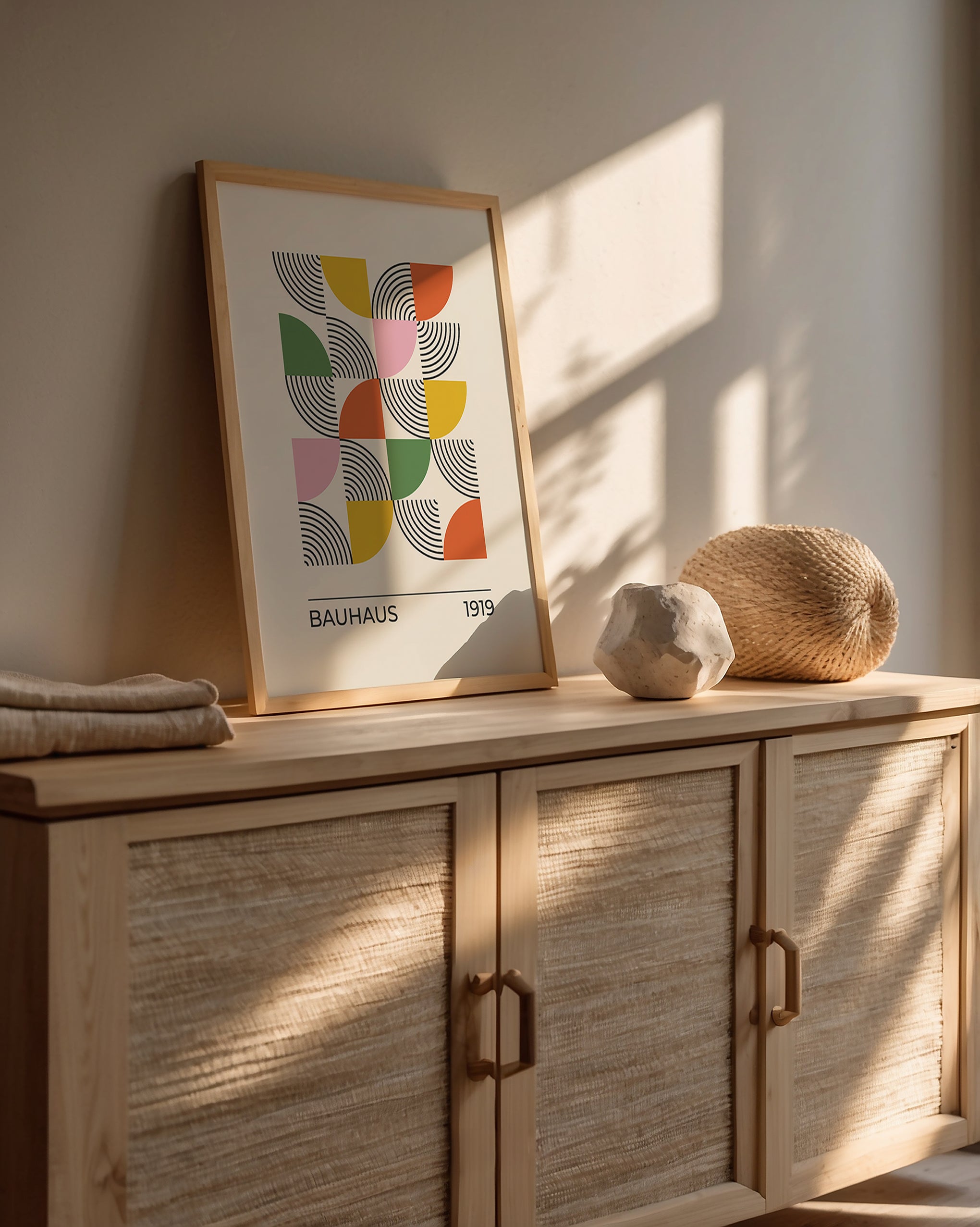 Bauhaus-inspired wall art featuring geometric shapes in bold colors, displayed in a sunlit interior setting.