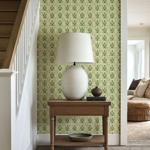 Entryway with geometric greenery wallpaper, featuring botanical patterns, a white table lamp on wooden table.