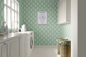 Modern abstract mint wallpaper with white leaf design in laundry room, ideal for children's playroom and nursery decor.