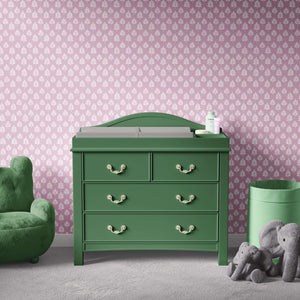 Gentle Leaves wallpaper featuring white leaf pattern on mauve-pink, ideal for modern nurseries with green furniture and plush toys.