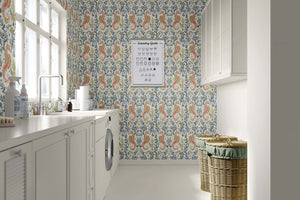 Coastal elegance with "Tidal Bloom" wallpaper featuring seahorses and seaweed in soothing pink, sage, and gold tones in a laundry room.