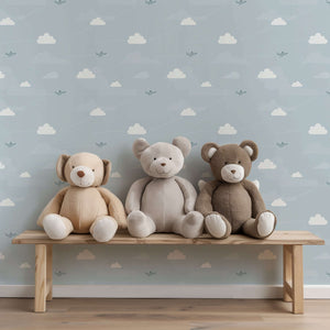 Flying High Wallpaper with airplanes and clouds in a children's nursery, featuring plush teddy bears on a wooden bench.