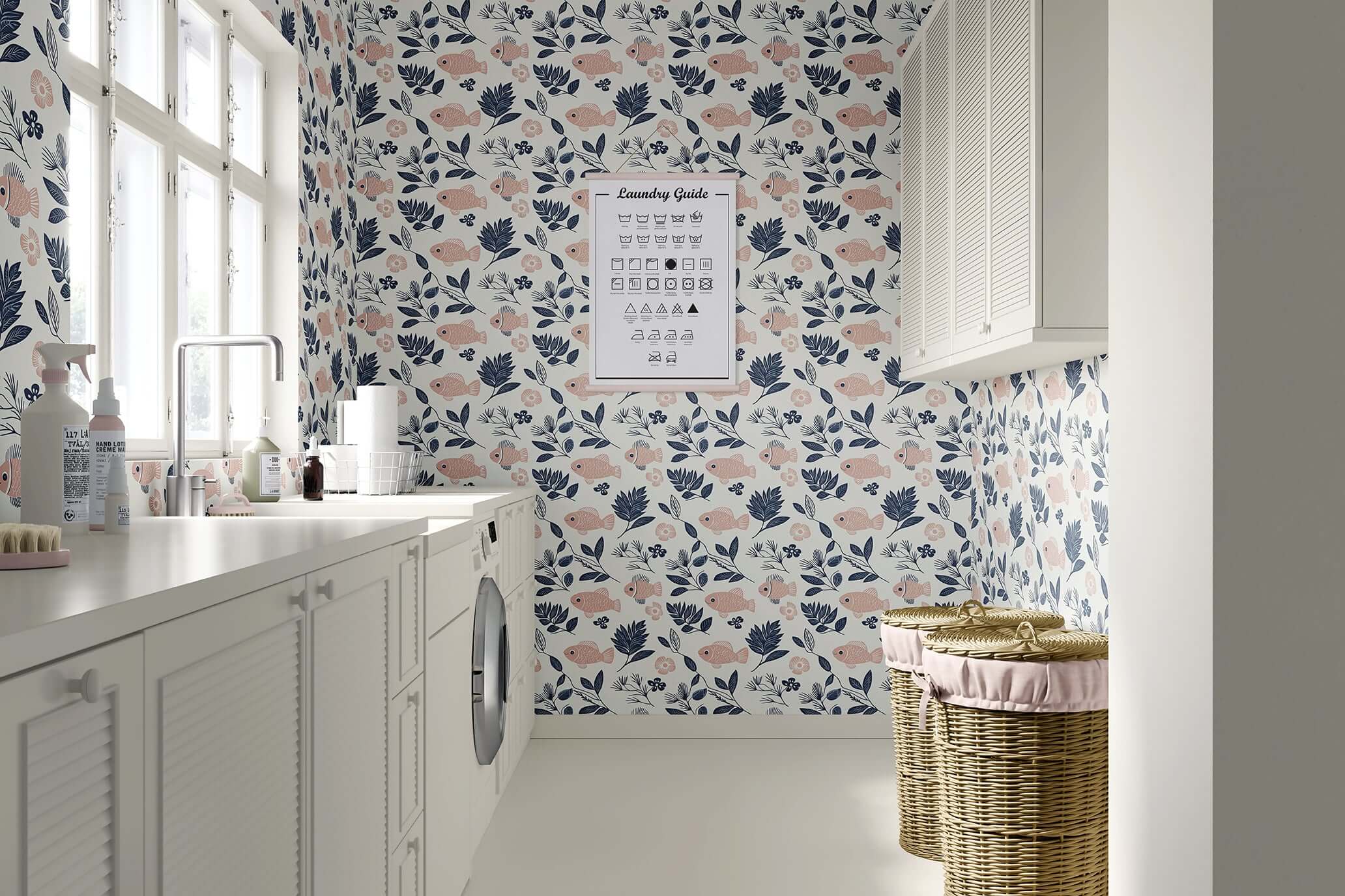 Fishy Florals wallpaper featuring blush fish and navy foliage in a coastal laundry room.
