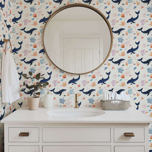 Bathroom with whimsical Whale of a Time coastal wallpaper featuring whales, colorful fish, seaweed, and coral, creating an ocean adventure.