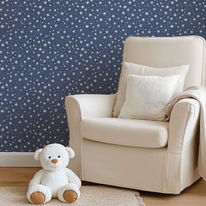 Nursery adorned with Twinkle Twinkle Little Star wallpaper featuring white and gold stars on navy, with a teddy bear and comfy chair.
