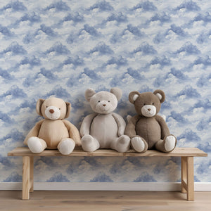 Cozy nursery with blue cloud wallpaper and three plush bears on a wooden bench, ideal for children's playroom décor.