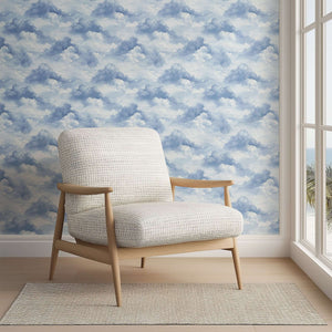Cozy chair in front of Serene Cloud Drift Wallpaper, perfect for nurseries and playrooms with a soothing sky theme.