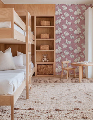 Cozy Cottontail Bliss wallpaper with fluffy bunnies on mauve-pink, perfect for children's nursery or playroom walls."