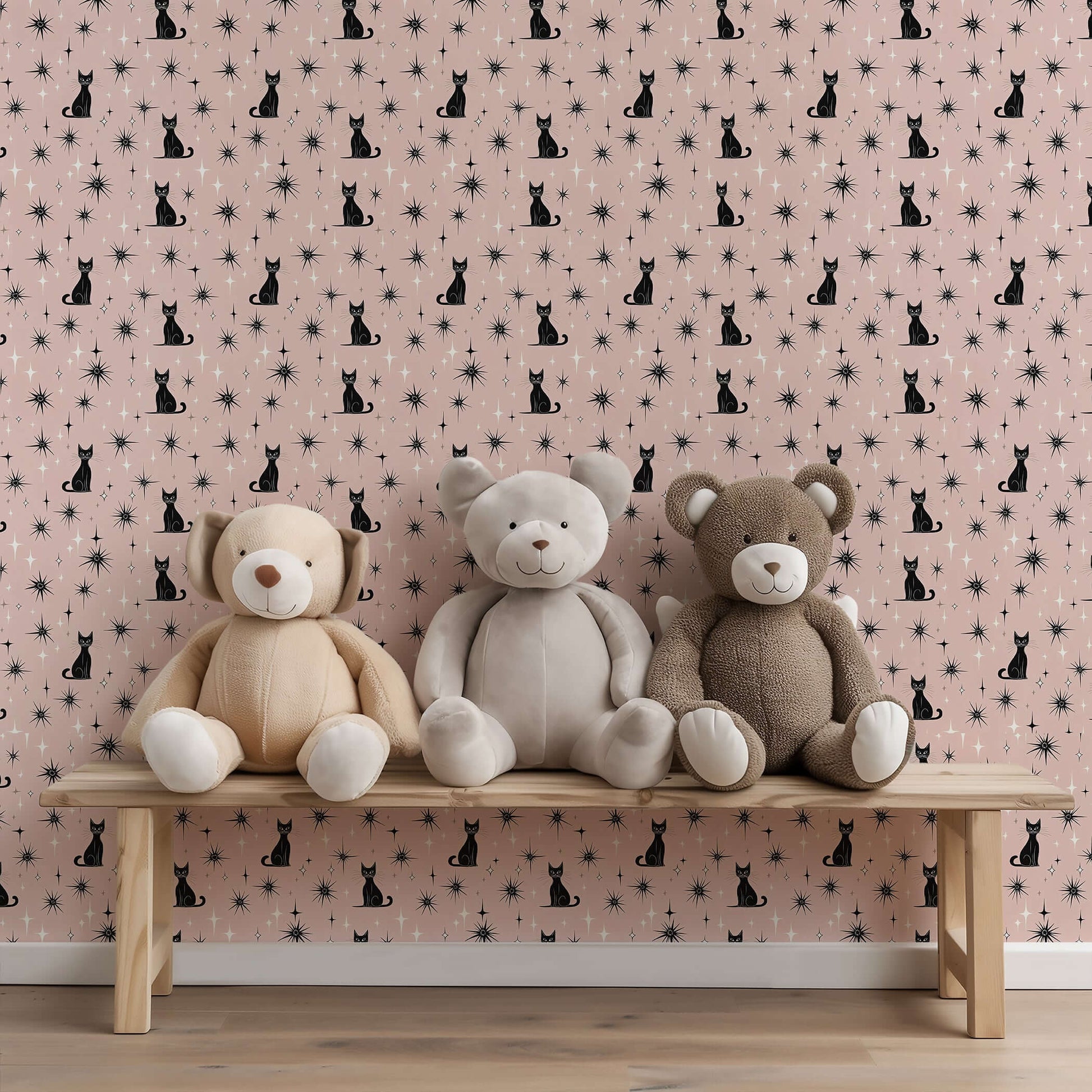 Twilight Catscape wallpaper with black cats and stars on a blush backdrop in a children’s room with plush teddy bears on a bench.