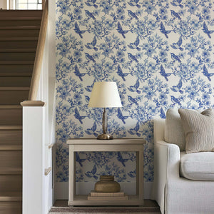 Blue-and-white Songbird Garden Toile wallpaper featuring birds and blossoms in a vintage French toile design for elegant interiors.