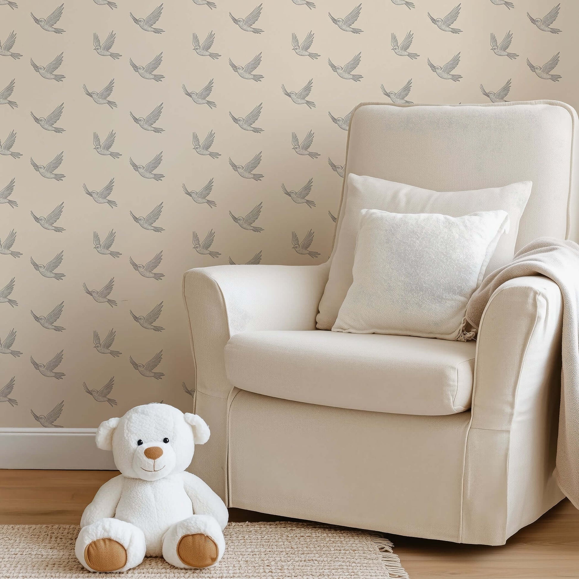 Modern monochrome wallpaper with soaring birds design in nursery setting, featuring a plush chair and teddy bear.