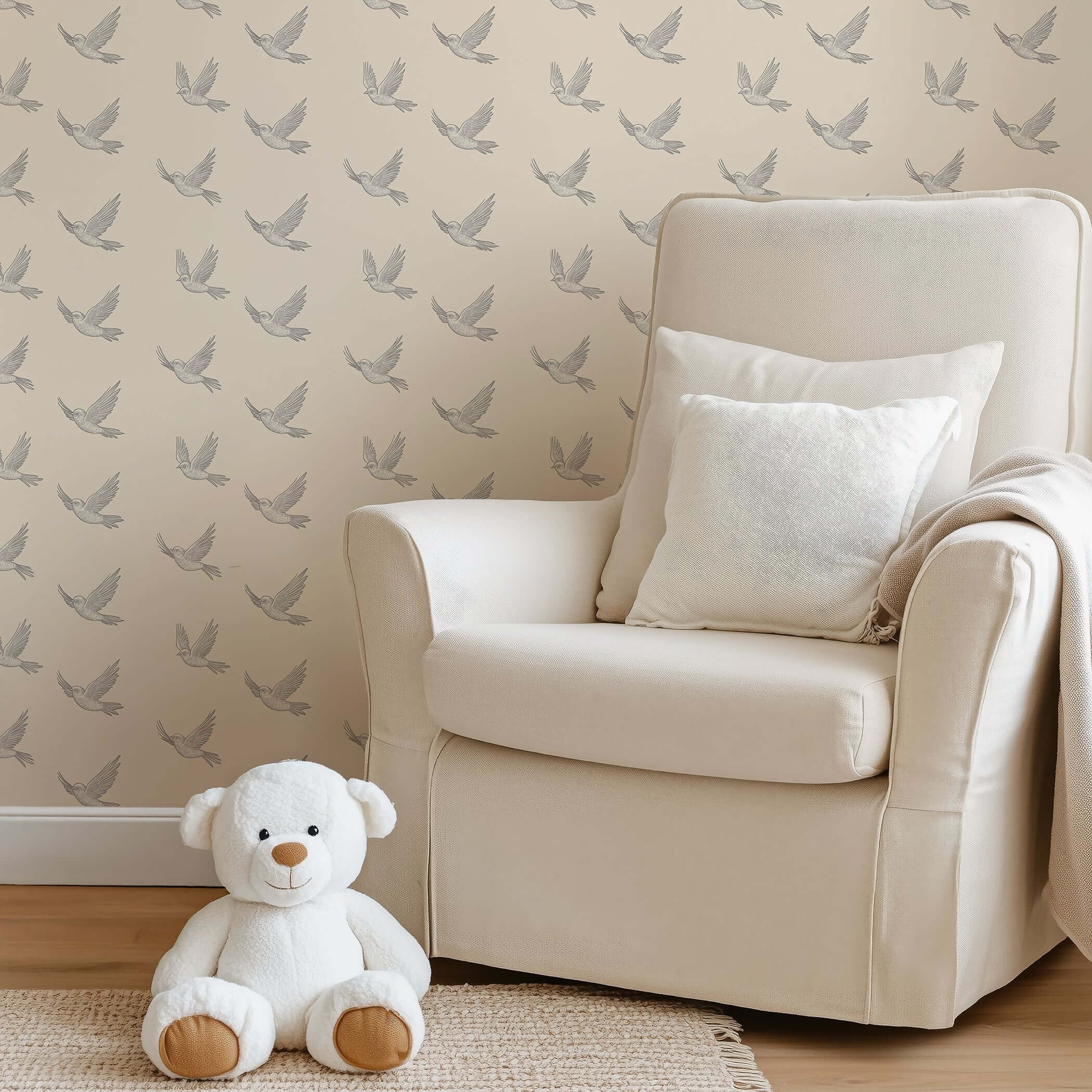 Modern monochrome wallpaper with soaring birds design in nursery setting, featuring a plush chair and teddy bear.