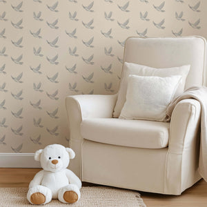 Modern monochrome wallpaper with soaring birds design in nursery setting, featuring a plush chair and teddy bear.
