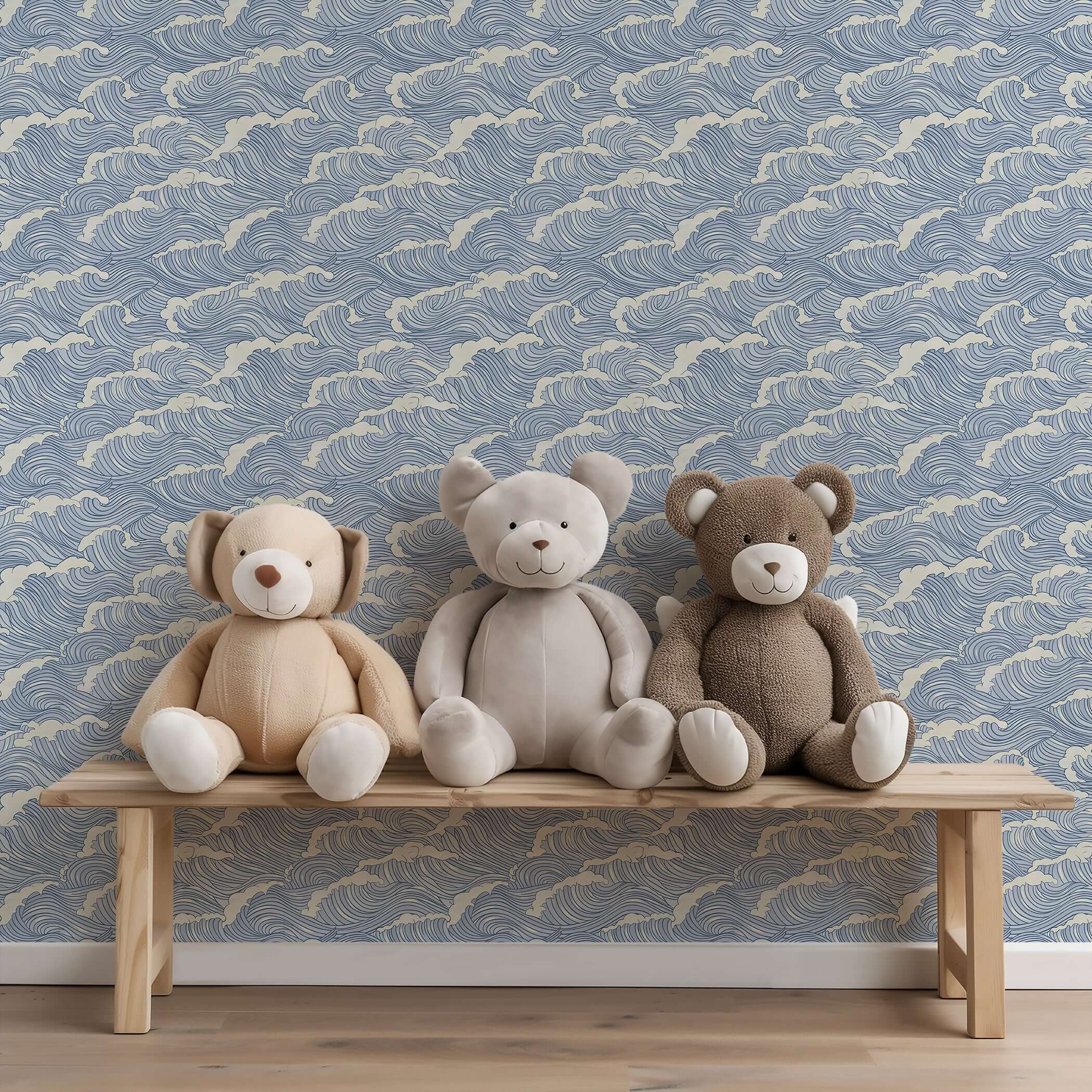 Coastal-themed nursery with Ocean Serenity wallpaper featuring wave patterns, behind a bench with three plush teddy bears, maritime ambiance.