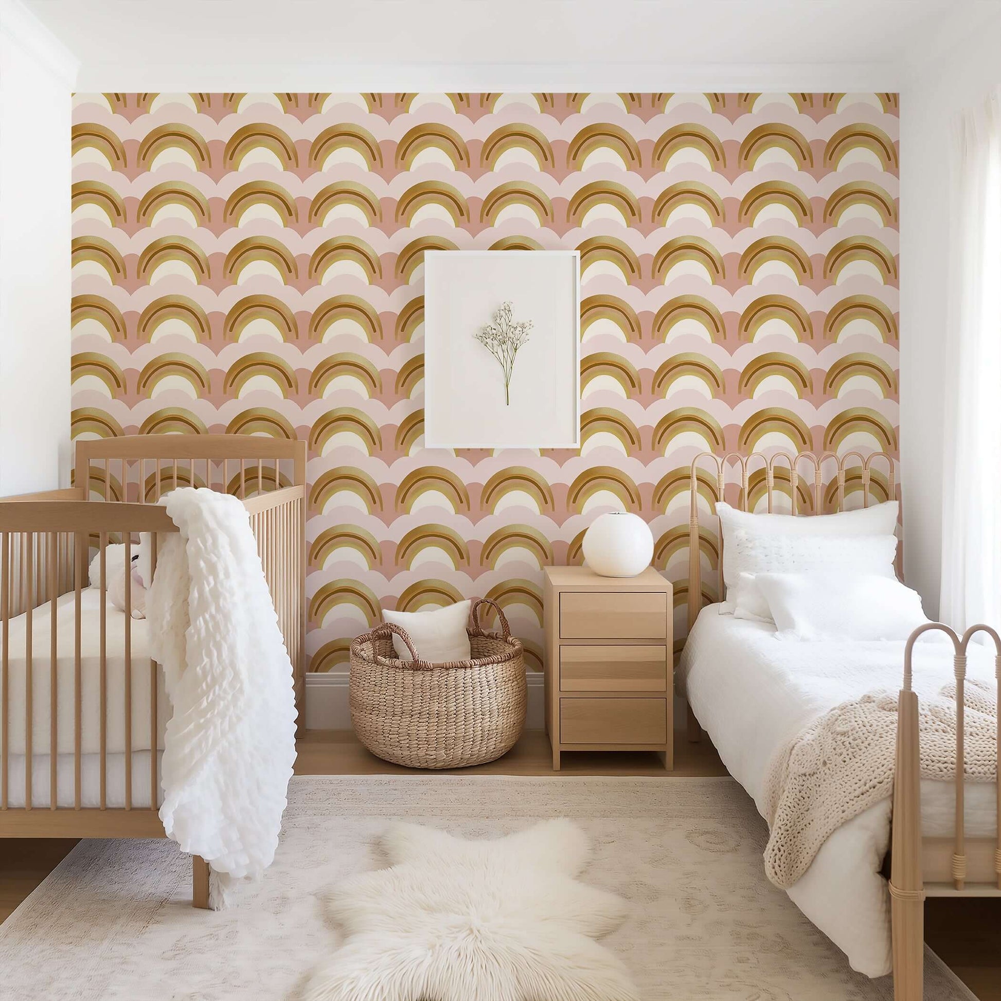Golden Dream Rainbows Wallpaper in nursery room with crib and bed, featuring gold, pink and cream tones, ideal for children’s decor.