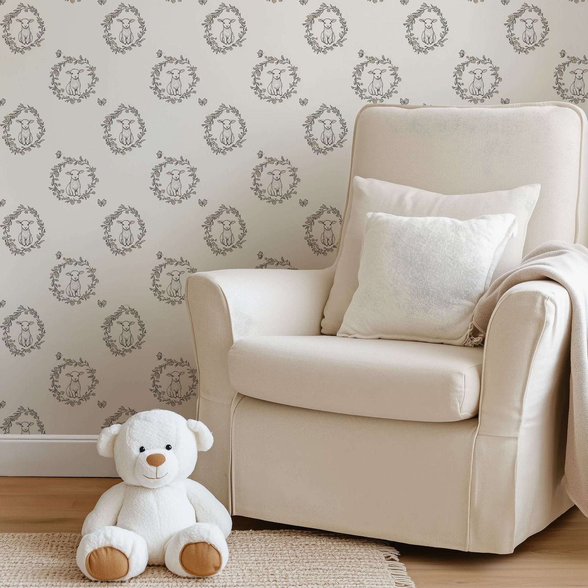 Cream wallpaper with baby lambs in floral wreaths, perfect for children’s nursery or playroom. Includes white teddy and comfy chair.