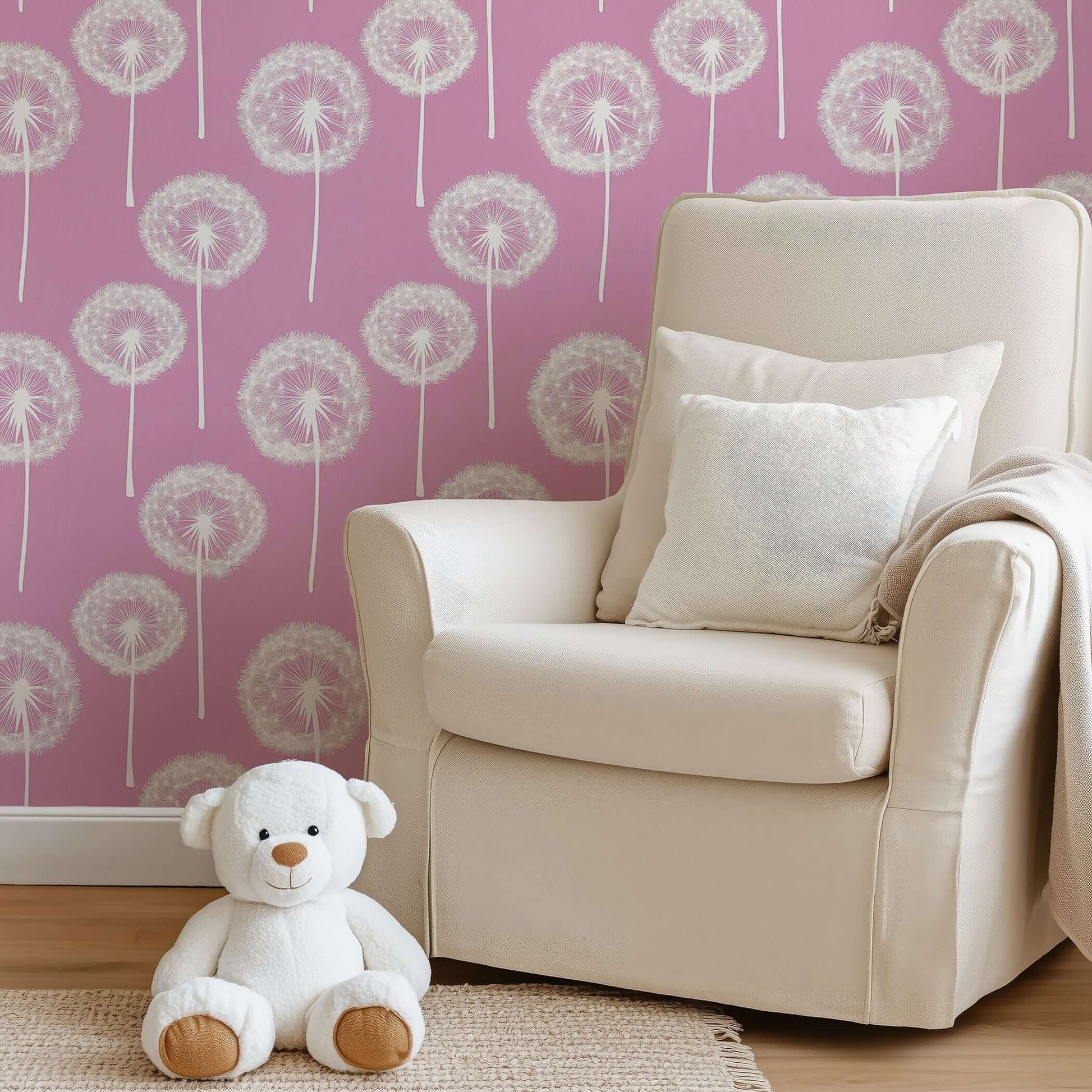Pink Puff Paradise wallpaper with white dandelions on rose-pink, featuring a cozy nursery scene with teddy bear and plush chair.