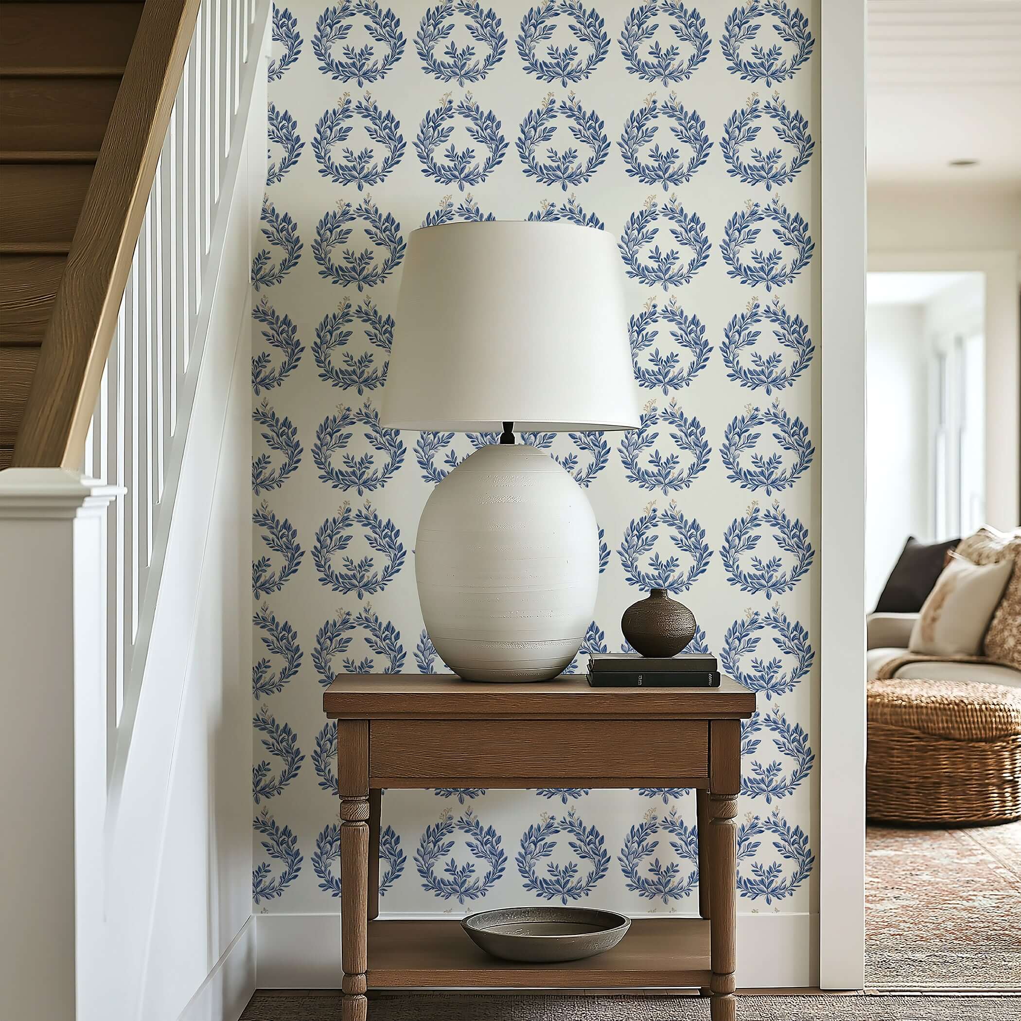 Navy laurel wreath wallpaper on ivory wall with elegant lamp and wooden table, enhancing a space with botanical luxury.