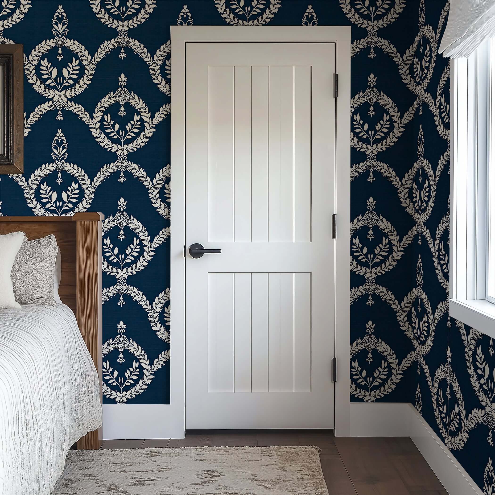 Room with dark navy wallpaper featuring ivory laurel wreaths and decorative crests, creating a sophisticated, vintage ambiance.