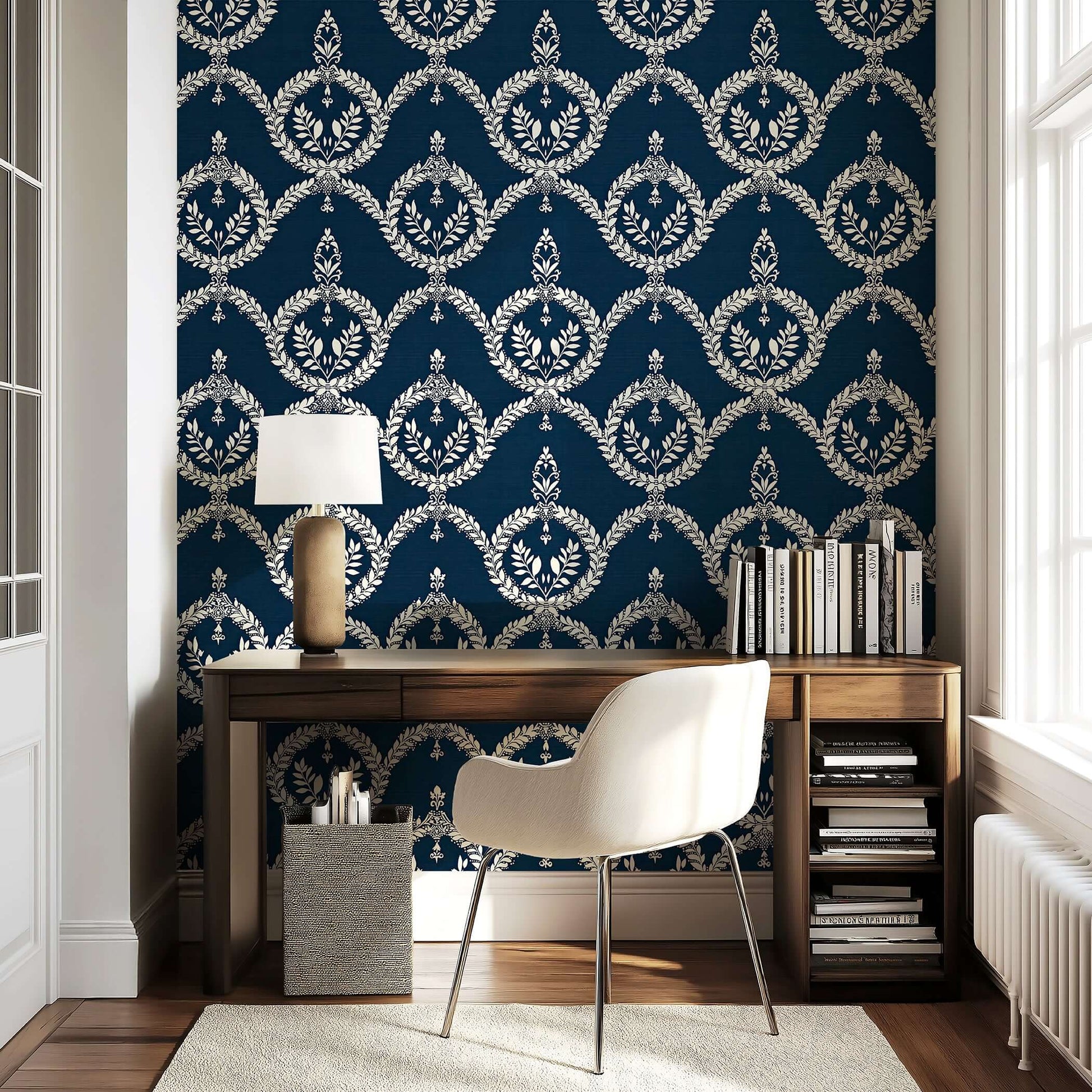 Elegant workspace featuring 'Vintage Crest' wallpaper with ivory laurel wreath patterns on a navy background, perfect for libraries.