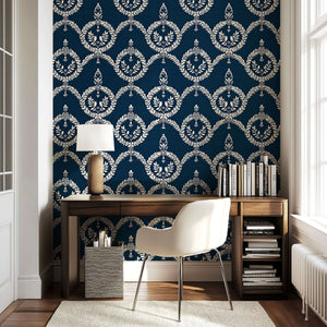Elegant workspace featuring 'Vintage Crest' wallpaper with ivory laurel wreath patterns on a navy background, perfect for libraries.
