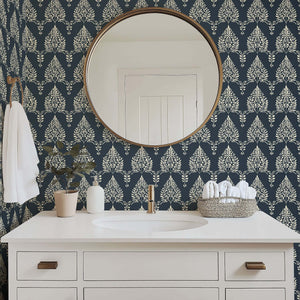 Noir Bloom wallpaper in a bathroom setting, featuring creamy floral laurels and laurel wreaths against a charcoal background.