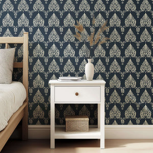Noir Bloom wallpaper with creamy floral and laurel wreath silhouettes against a charcoal background in a bedroom setting.