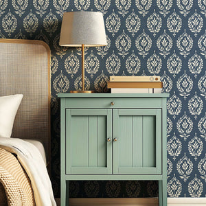 Traditional wallpaper with slate blue and ivory laurel wreath motifs brings vintage charm and elegance to home interiors.