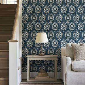 Classic slate blue wallpaper with ivory laurel wreath motifs, adding traditional elegance and floral charm to home interiors.