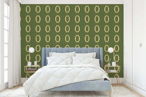 Bedroom with Golden Ovals wallpaper featuring interlocking gold ovals on an olive-green background creating a mid-century modern vibe.