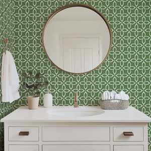 Modern bathroom with Verdant Minimalism wallpaper featuring geometric flower patterns in white on sage green behind a sleek vanity.