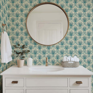 Art Deco bathroom with teal and tan coastal wallpaper featuring scallop motifs, complementing modern white vanity and circular mirror.